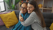 © Krakenimages.com - An affectionate mother and daughter embracing in a cozy living room, radiating love and family bond.