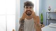 © Krakenimages.com - Handsome hispanic man with beard smiling in wellness center spa room