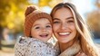 © Pinklife - A mother and her child enjoy a beautiful autumn day outdoors, dressed in warm knitwear, sharing joyous smiles, and creating lasting memories in the golden-hued fall landscape.