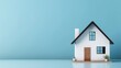 © glden - Minimalist real estate & property market banner of  small house model on the floor against a light blue wall background with plenty of space for text, images and additional marketing content.
