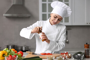 Wall Mural - Professional chef seasoning tomatoes at table in kitchen