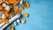 © Pinklife - An artistic arrangement of birch branches paired with autumn leaves lies on a blue background, capturing the autumnal essence with natural beauty and a touch of creativity.