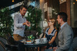 © qunica.com - Casual business meeting in an outdoor cafe as colleagues engage in a lively discussion. Perfect for concepts of teamwork, collaboration, and relaxed professional environments.