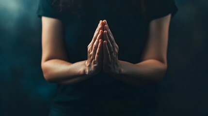 A photograph of a person with their hands clasped together in a prayerful gesture isolated on a simple clean background  The image conveys a sense of spiritual reflection meditation and inner peace