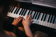 © qunica.com - Close-up of two people's hands playing the piano together, highlighting teamwork, coordination, and musical skills