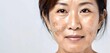 © lovelyday - Close-up face skin of middle-aged Asian woman with dark spots melasma or freckles on copy space white background. Hyperpigmentation caused by hormonal changes, genetics or sun exposure