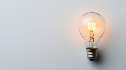 Poster - glowing light bulb symbol of a new breakthrough on a clean white background with copy space for text