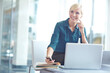 © ReeseBuyout2/peopleimages.com - Business woman, laptop and phone for research, website and online application in office with books. Receptionist, technology and smile for project workflow, administration and networking in workplace