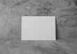 © grapestock - Empty white horizontal rectangle A4 paper sheet mockup on grey concrete floor and wall, 3D rendering