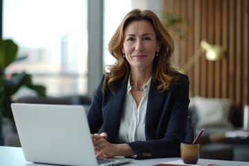 Wall Mural - Professional investment advisor at desk with laptop  smiling at camera.