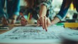© Faxri - Designers at an office, working on a blueprint on a table. Notice the woman's hand pointing to the drawing.
