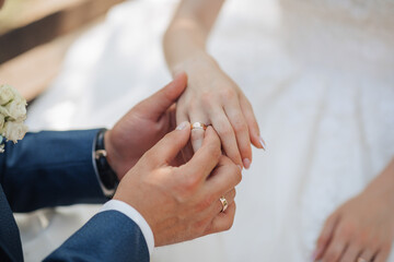 Wall Mural - A man and woman are getting married and the man is putting a ring on the woman's finger