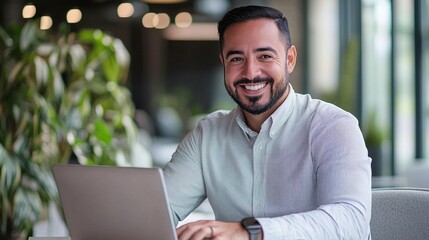 Poster - businessman smiling as he works on a laptop in a modern office, focusing on e-commerce