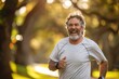 © Алена Ваторина - Happy older man jogging in a sunlit park with a big smile