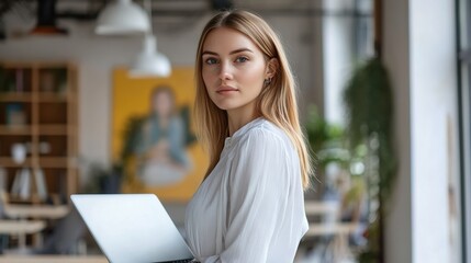 Poster - portrait of a young female entrepreneur with a laptop in a stylish office, confident and engaging