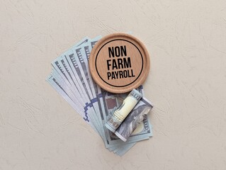 banknotes and round wooden with the words NON FARM PAYROLL