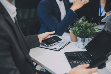 Group of colleagues engaging in a discussion during a business meeting in a conference room. Happy business people, men and women, collaborating and working towards their shared goals.