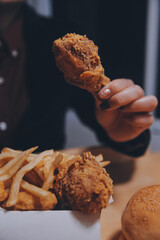 Wall Mural - close up focus woman hand hold fried chicken for eat,girl with fast food concept