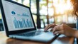 © Humeyra - Closeup of a businesswoman or accountant working on a laptop with analytical business reports graphs and finance charts focusing on financial and investment concepts