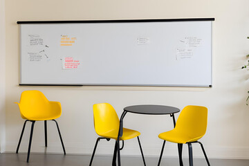 A modern office room with a table, chairs, and a lamp