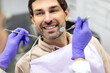 © Home-stock - Closeup shot of dentist examining male patients teeth in dental clinic. Man having his teeth examined by female dentist