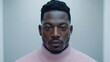 © vimp - A confident man in a pink turtleneck captivates with his striking gaze in a soft-lit room