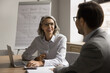 © fizkes - Happy mature woman negotiates with partner at conference table, lead pleasant business conversation, planning cooperation, working on task, selling company services to client during meeting in office