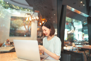 Asian woman using laptop and waiting at coffee cafe city break weekend balance lifestyle