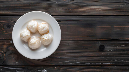 Poster - Plate of delicious soup dumplings is sitting on a dark wooden table with copy space