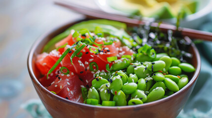 Wall Mural - a fresh poke bowl, featuring marinated tuna, avocado, edamame, and seaweed salad, artfully arranged in a bowl with chopsticks, set against a bright, clean background