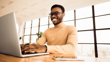Poster - Writing A Blog Post. Satisfied afro blogger uploading photos, updating account information. Free space