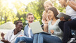© Prostock-studio - Group of emotional multiethnic students celebrating success, checking exam results online in park, copy space