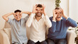 © Prostock-studio - Grandfather, Father And Son Having Fun Holding Fingers Near Eyes Like Eyeglasses Sitting On Sofa Indoor. Panorama