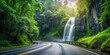 Asphalt road winding along a lush forest with a beautiful waterfall in the background, asphalt, road, pathway, forest