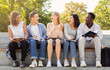 © Prostock-studio - Cheerful international students studying and talking, sitting on stairs in park