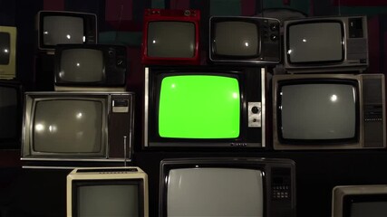 Wall Mural - dolly in on green screen old tv amongst many vintage 80s and 90s tvs - you can replace green screen 