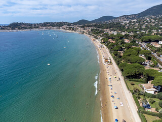 Aerial view on boats, crystal clear blue water of Plage du Debarquement white sandy beach near Cavalaire-sur-Mer and La Croix-Valmer, summer vacation on French Riviera, Var, France