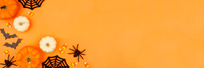 Aufkleber - Halloween corner border of black, white and orange color candies, pumpkins and spooky decor. Top down view on an orange banner background with copy space.