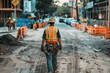 © ylivdesign - Construction worker wearing a hard hat and safety vest is walking down a dirt road on a city street