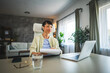 © Miljan Živković - Mature japanese woman with earphones work from home on laptop