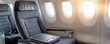 © JAYDA RIN - Interior of an airplane showing empty seats and windows, highlighting travel comfort and modern aviation design.