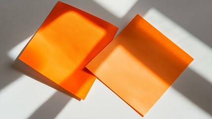 Poster - two vibrant orange sheets on a white surface evoke creativity and elegance in simplicity.