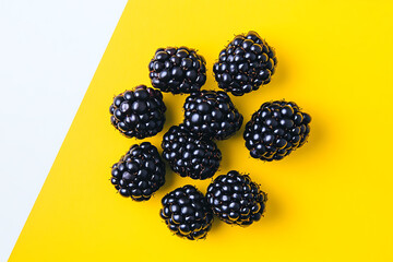 Wall Mural - A close-up of fresh blackberries on a vibrant yellow background.