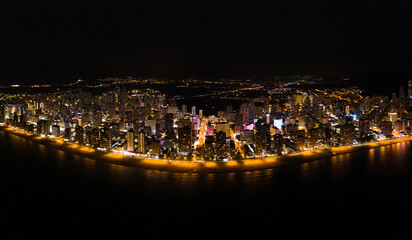 Wall Mural - Skyline of Spanish city Benidorm, at night. Street lights. Light reflection in water. Spectacular travel destination in south of Spain, Alicante province.  