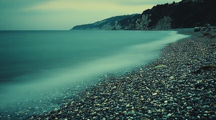 Poster -   A vast expanse of water adjacent to a rugged shoreline perched atop a verdant slope, overlooking the sea