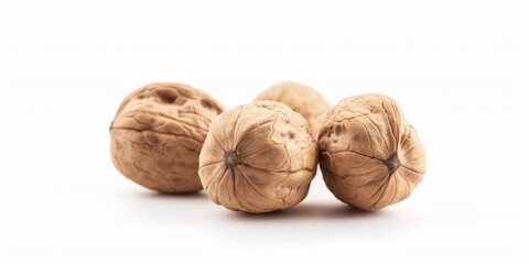 Wall Mural - Four walnuts are sitting on a white background. They are all different sizes and shapes. The walnuts are all brown and appear to be slightly cracked