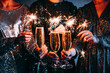 © FornStudio - Friends celebrating Christmas or New Year eve party with Bengal lights and champagne.