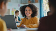 © Maciej Koba - Smiling student with a laptop in a classroom setting