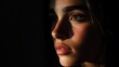 © pinporn manosri - A dark, moody portrait of a woman with soft light illuminating her face against a black background