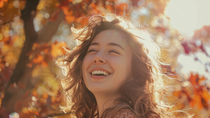 Wall Mural - A close-up view of a woman in motion, joyful expression, curls catching the sunlight, blurred background of trees and sky,